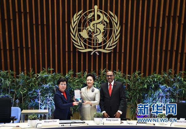 1月18日，国家主席习近平夫人、世界卫生组织结核病和艾滋病防治亲善大使彭丽媛应世界卫生组织总干事陈冯富珍和联合国艾滋病规划署执行主任西迪贝邀请，在瑞士日内瓦出席为她举行的亲善大使任期续延暨颁奖仪式。这是世界卫生组织总干事陈冯富珍向彭丽媛颁发世卫组织荣誉勋章。新华社记者谢环驰摄