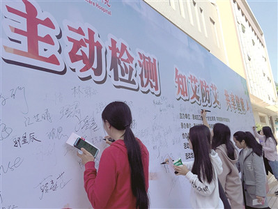 在艾滋病防治科普宣传活动中,大学生签名承诺主动防艾。 本报记者周 楠 摄